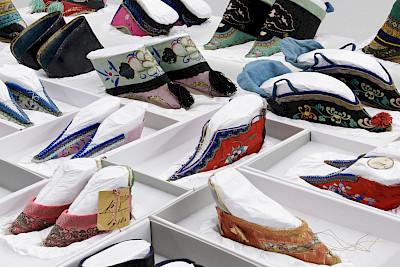 28 Paar Schuhe für gebundene Füsse bewahrt das Völkerkundemuseum UZH. Im 19. Jh. die Zierde einer Frau in China, wurden sie innert kurzer Zeit zum Makel, und: zu Plünderware?Foto: Kathrin Leuenberger, 2023.
