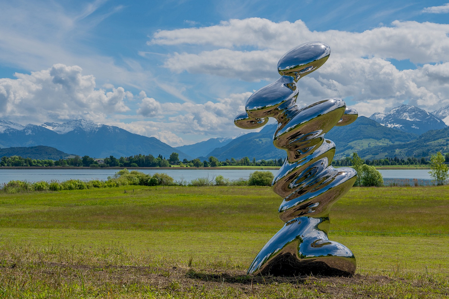 Carlo Borer, Stalagmite. Die hochglänzende Edelstahlskulptur reflektiert ihre Umgebung und tritt in einen ständigen Dialog
mit Licht, Landschaft und Betrachterinnen und Betrachtern.