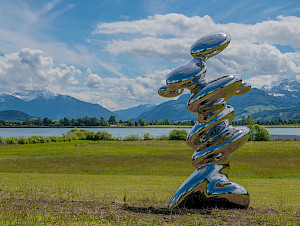 Carlo Borer, Stalagmite. Die hochglänzende Edelstahlskulptur reflektiert ihre Umgebung und tritt in einen ständigen Dialog
mit Licht, Landschaft und Betrachterinnen und Betrachtern.